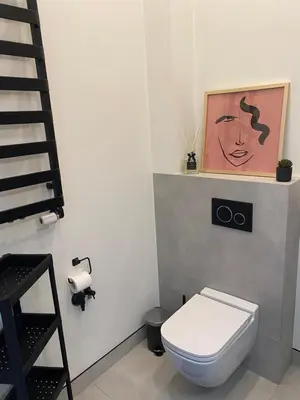 a bathroom with a toilet and a painting on the wall at Royal Rose Apartment - Old Town Kraków in Kraków