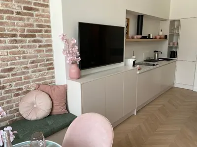 a living room with a tv on a white cabinet at Royal Rose Apartment - Old Town Kraków in Kraków