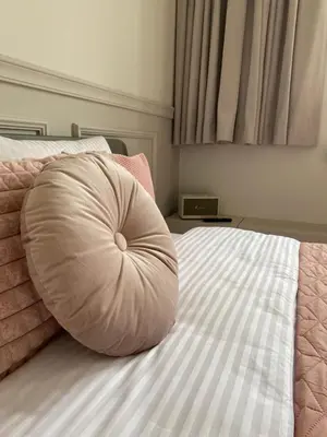 a round pillow sitting on top of a bed at Royal Rose Apartment - Old Town Kraków in Kraków