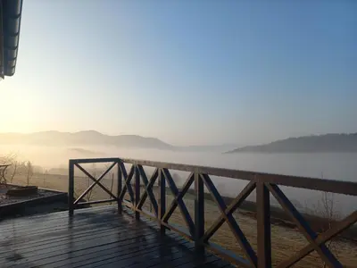a balcony with a view of the water and mountains at Domek na Brzeziu in Limanowa