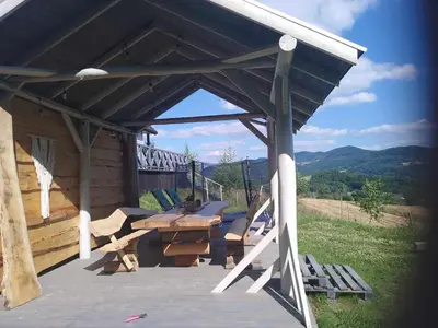 a pavilion with a picnic table on a deck at Domek na Brzeziu in Limanowa