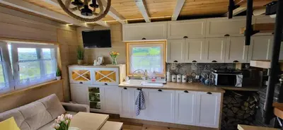 a kitchen with white cabinets and a counter top at Domek na Brzeziu in Limanowa