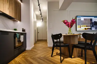 a living room with a table with chairs and a vase of flowers at Apartament Indigo 11 by Housine in Zator