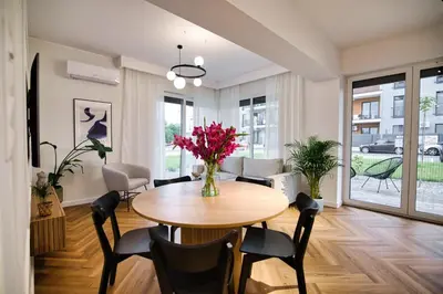 a dining room with a table with chairs and a vase of flowers at Apartament Indigo 11 by Housine in Zator