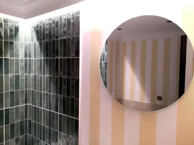 a bathroom with a mirror and a tiled wall at WANNA SPA na Starym Mieście in Kraków