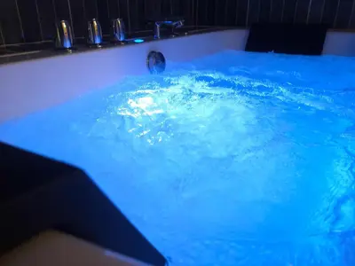 a pool of blue water with a person in it at WANNA SPA na Starym Mieście in Kraków