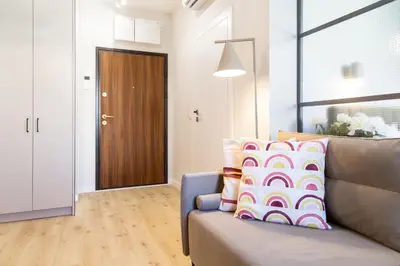 a living room with a couch and a brown door at Househost Apartment Smoleńsk 33-309A in Kraków