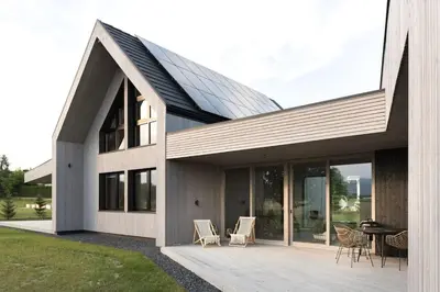a house with a deck with chairs and a table at Poczywaj in Jordanów