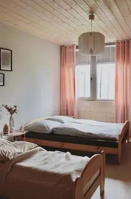 a bedroom with two beds and a window at Poczywaj in Jordanów