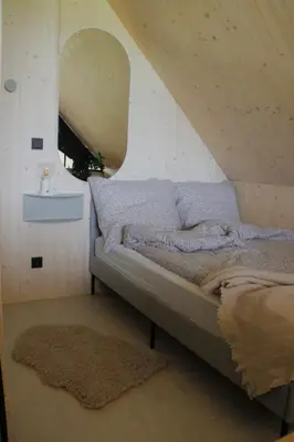 a bedroom with a bed with a large mirror at Poczywaj in Jordanów