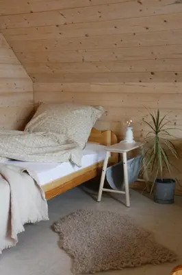 a bedroom with a bed with a wooden wall at Poczywaj in Jordanów