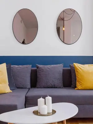 a living room with a blue couch and two mirrors at Kazimierz- Warszauera 3 Street in Kraków