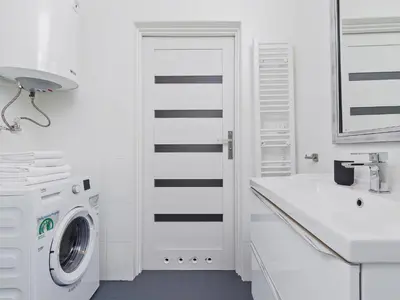 a white bathroom with a washing machine and a sink at Kazimierz- Warszauera 3 Street in Kraków