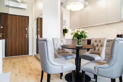 a dining room with a table with chairs and a vase of flowers at Househost Apt Smoleńsk 33-308A in Kraków