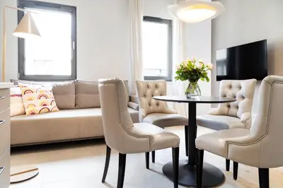 a living room with a couch and a table and chairs at Househost Apt Smoleńsk 33-308A in Kraków