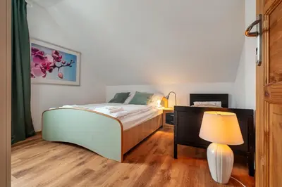 a bedroom with a large bed and a staircase at Villa Teresa in Trzebinia
