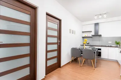 a kitchen with a wooden door and a table and chairs at Modern Apartments II with FREE underground parking in Kraków