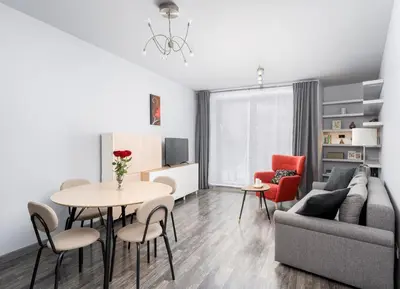 a living room with a couch and a table and chairs at Modern Apartments II with FREE underground parking in Kraków