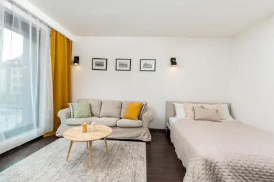 a living room with a couch and a table at Modern Apartments II with FREE underground parking in Kraków