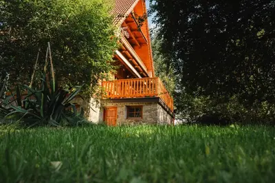 a large wooden house with a balcony and stairs at Chata pod Szczeblem in Lubień