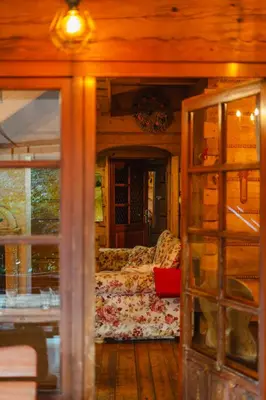 a living room with a couch and a glass door at Chata pod Szczeblem in Lubień