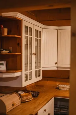 a kitchen with white cabinets and a wooden counter top at Chata pod Szczeblem in Lubień