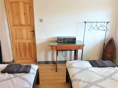 a room with two beds and a table and a door at Dom pod Wieliczką in Wieliczka
