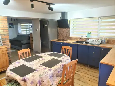 a kitchen with a table and a kitchen with blue cabinets at Dom pod Wieliczką in Wieliczka