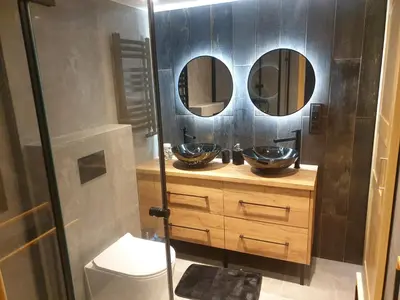 a bathroom with two sinks and two mirrors at Dom pod Wieliczką in Wieliczka