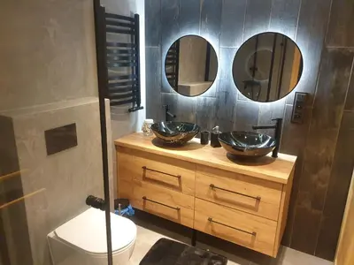 a bathroom with two sinks and a toilet and two mirrors at Dom pod Wieliczką in Wieliczka