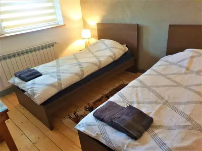 a room with two beds and a lamp on the wall at Dom pod Wieliczką in Wieliczka