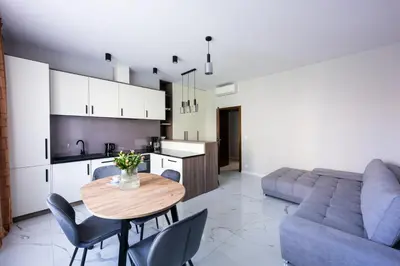 a kitchen and living room with a table and a couch at Native Apartments Słowackiego 14/6 Deluxe in Kraków