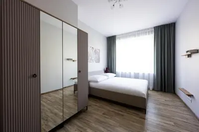 a kitchen with white cabinets and a black counter top at Native Apartments Słowackiego 14/6 Deluxe in Kraków