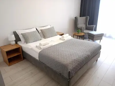a bedroom with a large bed and two chairs at Zakrzówek Residence in Kraków