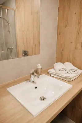 a bathroom with a white sink and a mirror at Zakrzówek Residence in Kraków