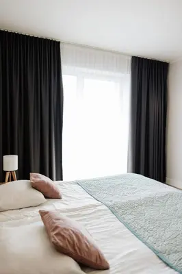 a bedroom with a bed and a large window at Zakrzówek Residence in Kraków
