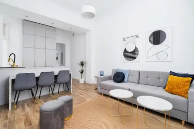 a living room with a couch and tables and a kitchen at Apartment with balcony - Starowislna 41 in Kraków