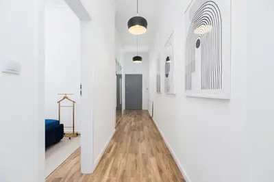 an empty hallway with white walls and wood floors at Apartment with balcony - Starowislna 41 in Kraków