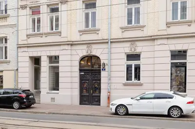 two cars parked in front of a building with a door at Apartment with balcony - Starowislna 41 in Kraków