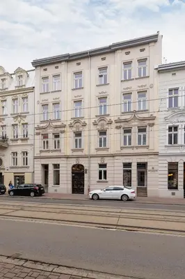 a white car parked in front of a large building at Apartment with balcony - Starowislna 41 in Kraków