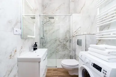 a white bathroom with a toilet and a shower at Apartment with balcony - Starowislna 41 in Kraków