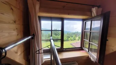 a room with a large window in a log cabin at Chata Drapula - Gospodarstwo Agroturystyczne - Apartament na wyłączność z widokiem na góry i aneksem kuchennym in Zawadka