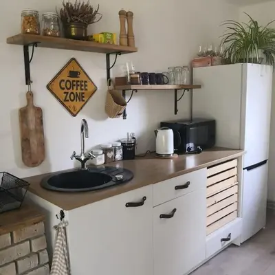 a kitchen counter with a sink and a refrigerator at Bluszcz i Lawenda in Jankowice