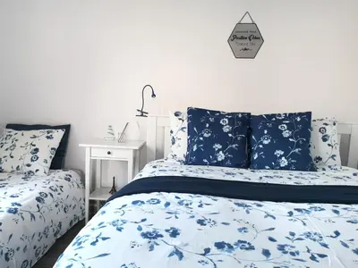 a bedroom with a bed with blue and white sheets at Bluszcz i Lawenda in Jankowice