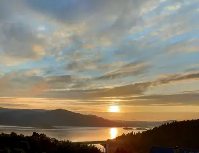 a sunset over a body of water with the sun at DOMEK W HORTENSJACH in Mucharz