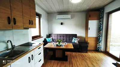 a kitchen and living room with a couch and a table at DOMEK W HORTENSJACH in Mucharz
