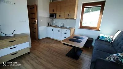 a small living room with a table and a couch at DOMEK W HORTENSJACH in Mucharz