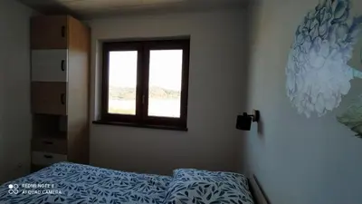 a bedroom with a bed and a window at DOMEK W HORTENSJACH in Mucharz