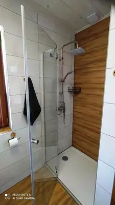 a shower with a glass door in a bathroom at DOMEK W HORTENSJACH in Mucharz