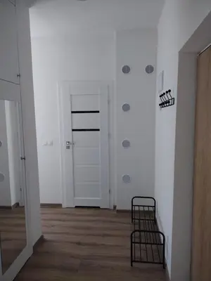 a hallway with a door and a chair in a room at Good Apartament Skawina in Skawina